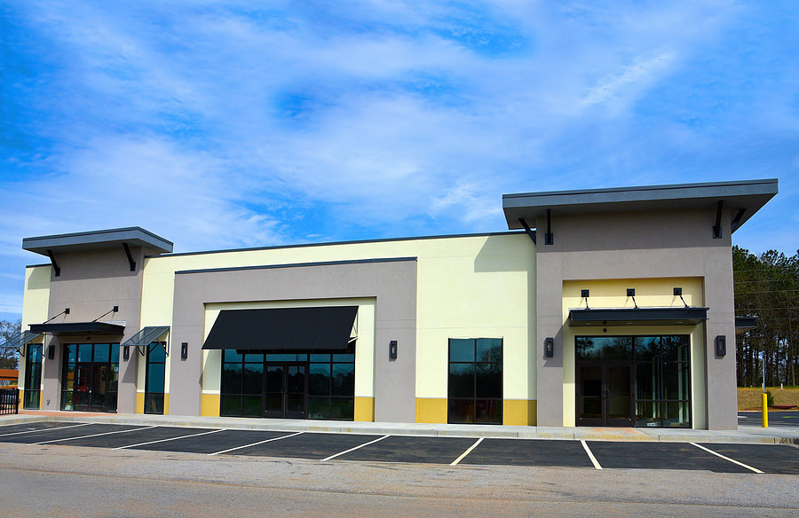 commercial establishment with glass door and front parking lot